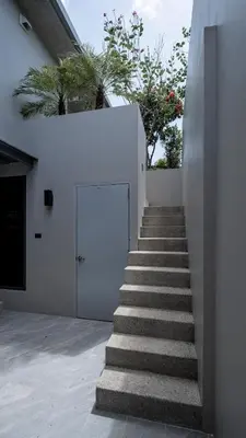 a staircase leading up to a white building with a door at Luxury Modern Loft Villa Riverhouse in Laguna Phuket