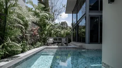 a swimming pool in a house with a garden at Luxury Modern Loft Villa Riverhouse in Laguna Phuket