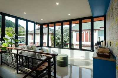 a living room with large windows and a couch at Kewalin hostel in Phi Phi Don