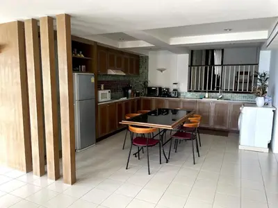a kitchen with a table and chairs and a refrigerator at 3-bed house with Private beach in Ban Ao Makham