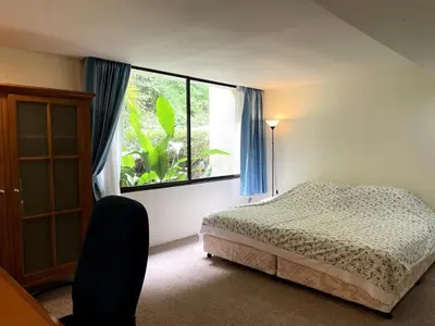 a bedroom with a bed and a large window at 3-bed house with Private beach in Ban Ao Makham