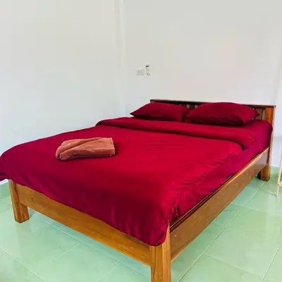 a large bed with a red blanket on it at Lamsai AC Sea House Green in Ko Yao Noi