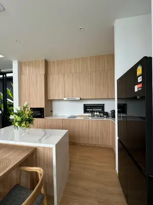 a kitchen with wooden cabinets and a white counter top at Villa Aileen Naithon in Nai Thon Beach
