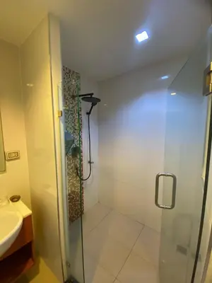 a bathroom with a glass shower and a sink at Sea View & Pool Apartment in Phuket Town