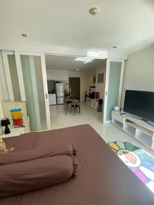 a living room with a couch and a flat screen tv at Sea View & Pool Apartment in Phuket Town