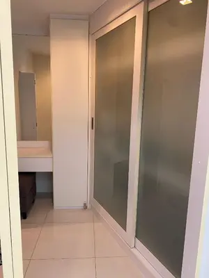 a walk in closet with sliding glass doors at Sea View & Pool Apartment in Phuket Town