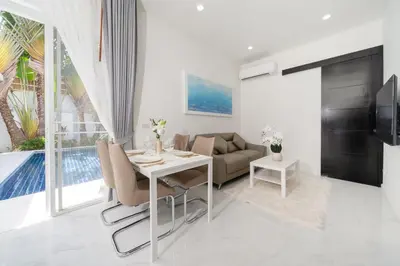 a living room with a table and a couch at The Greens Phuket Villa with swimming pool 18 in Ban Saiyuan (1)