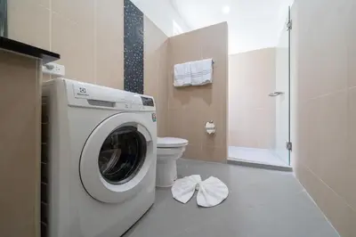 a bathroom with a washing machine and a toilet at The Greens Phuket Villa with swimming pool 18 in Ban Saiyuan (1)