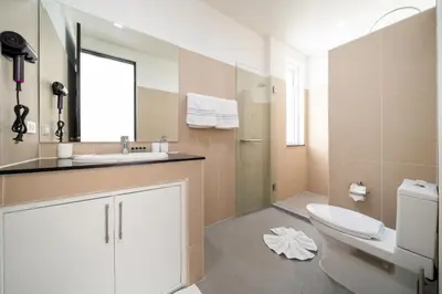 a bathroom with a toilet and a sink and a mirror at Brand New 3 Bedroom Pool Villa 18 in Ban Saiyuan (1)