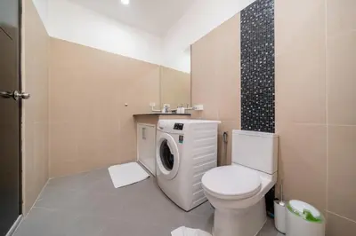 a bathroom with a toilet and a washing machine at Brand New 3 Bedroom Pool Villa 18 in Ban Saiyuan (1)