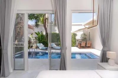 a bedroom with a view of a swimming pool at Brand New 3 Bedroom Pool Villa 18 in Ban Saiyuan (1)