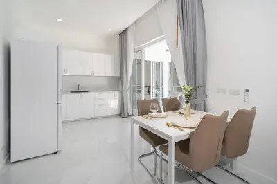a white dining room with a white table and chairs at Brand New 3 Bedroom Pool Villa 18 in Ban Saiyuan (1)