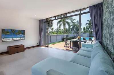 a living room with a blue couch and a large window at Modern Comfort in Paradise - Villa Argent 6 with 3BR and Access to Tropical Pool in Thalang