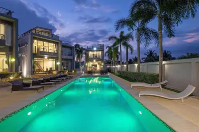 a swimming pool in front of a house at Modern Comfort in Paradise - Villa Argent 6 with 3BR and Access to Tropical Pool in Thalang