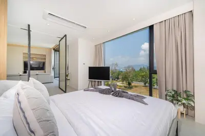 a bedroom with a large white bed and a large window at Penthouse Luxurious Seaview Patong in Patong Beach