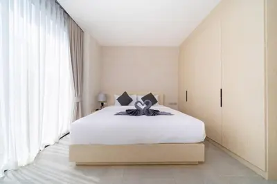 a bedroom with a large white bed and large windows at Penthouse Luxurious Seaview Patong in Patong Beach