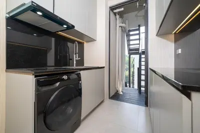 a kitchen with a washer and dryer next to a door at Penthouse Luxurious Seaview Patong in Patong Beach
