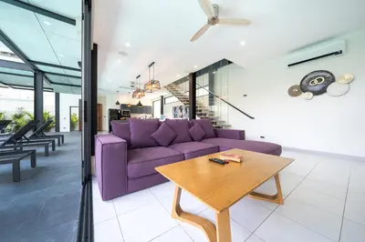 a living room with a purple couch and a wooden table at Innovative 4BR Villa Sunset Garden 1 with Oxygen Pool in Rawai Beach