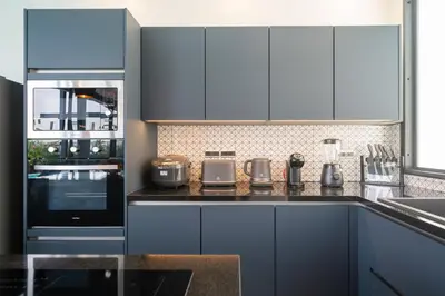a kitchen with blue cabinets and a counter top at Innovative 4BR Villa Sunset Garden 1 with Oxygen Pool in Rawai Beach