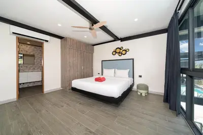 a bedroom with a bed and a ceiling fan at Innovative 4BR Villa Sunset Garden 1 with Oxygen Pool in Rawai Beach