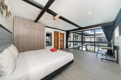 a bedroom with a white bed and a ceiling fan at Innovative 4BR Villa Sunset Garden 1 with Oxygen Pool in Rawai Beach