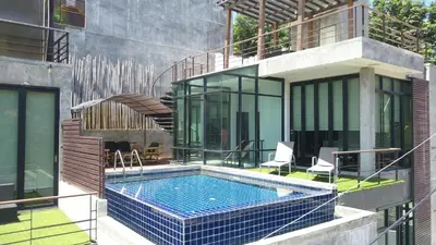 a house with a swimming pool next to a building at Villa Patong 3 Chambres in Patong Beach