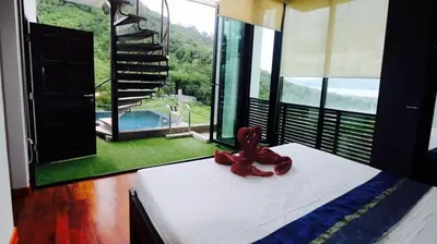 a bed with a pair of shoes on top of it at Villa Loma 4 Chambres in Patong Beach