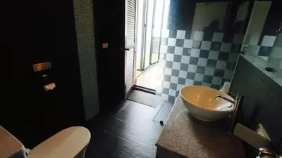 a black and white bathroom with a sink and a toilet at Villa Loma 4 Chambres in Patong Beach