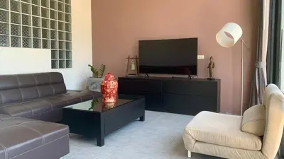 a living room with a couch and a tv at Villa Loma 3 Chambres in Patong Beach