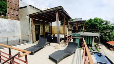 a deck with two chairs and a building at Villa Loma 3 Chambres in Patong Beach