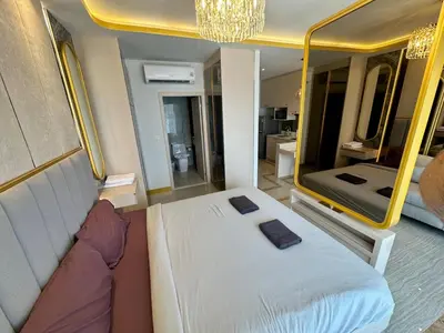 a bedroom with a bed and a large mirror at Bellevue Lagoon Phuket in Laguna Phuket