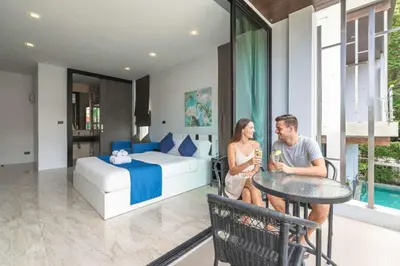 a man and woman sitting at a table in a bedroom at Vibrant Life at 4BR Pool Villa, Kata - UTK3 in Kata Beach