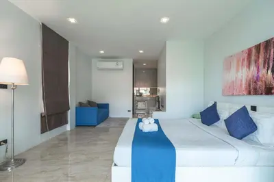 a bedroom with a large bed with a teddy bear on it at Vibrant Life at 4BR Pool Villa, Kata - UTK3 in Kata Beach