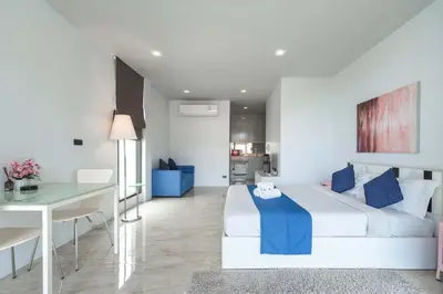 a bedroom with a white bed and a dining table at Vibrant Life at 4BR Pool Villa, Kata - UTK3 in Kata Beach