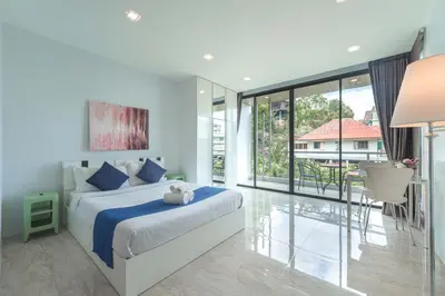 a bedroom with a bed and a large window at Vibrant Life at 4BR Pool Villa, Kata - UTK3 in Kata Beach