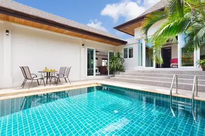 a swimming pool with a table and chairs next to a house at Thai-Balinese Villa Alex in Rawai, 3BR, Private Pool in Rawai Beach