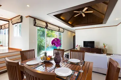 a dining room with a wooden table and chairs at Thai-Balinese Villa Alex in Rawai, 3BR, Private Pool in Rawai Beach