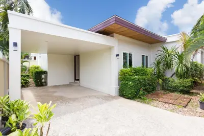 a white house with palm trees in front of it at Thai-Balinese Villa Alex in Rawai, 3BR, Private Pool in Rawai Beach