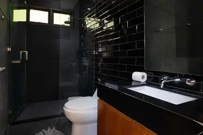 a bathroom with a sink and a toilet and black tiles at Thai Balinese Villa Rico in Kamala 3BR, Private Pool in Kamala Beach