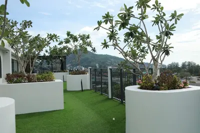 a balcony with white planters with trees and grass at Fantasea Kamala 1 BR Apartments Near Beach 212 in Kamala Beach