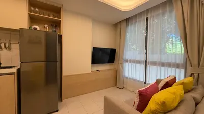 a living room with a couch and a tv and a window at Fantasea Kamala 1 BR Apartments Near Beach 212 in Kamala Beach
