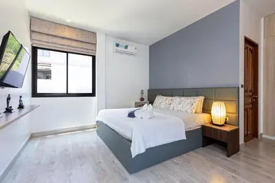 a bedroom with a bed and a window at Phuket Nai Han Beach Villa with Pool in Rawai Beach