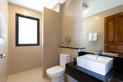 a bathroom with a white sink and a toilet at Phuket Nai Han Beach Villa with Pool in Rawai Beach