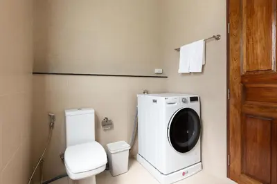 a bathroom with a washing machine and a toilet at Phuket Nai Han Beach Villa with Pool in Rawai Beach