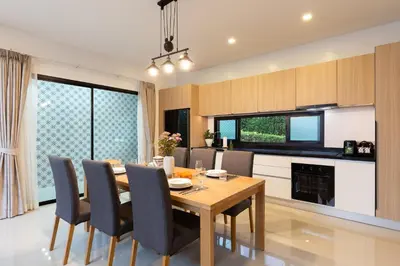 a kitchen and dining room with a wooden table and chairs at Phuket Nai Han Beach Villa with Pool in Rawai Beach