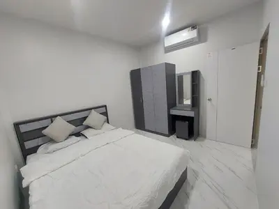 a white bedroom with a bed and a television at 629 Home for rent, Rawai in Ban Saiyuan (1)
