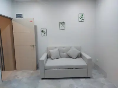 a grey chair sitting in a room next to a wall at 629 Home for rent, Rawai in Ban Saiyuan (1)
