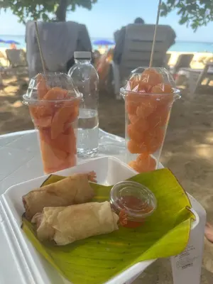a plate of food with fruit and drinks on a table at Wyndham studio 2205 in Surin Beach