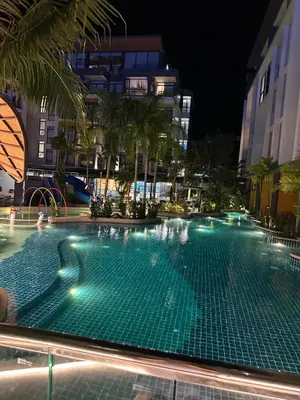 an empty swimming pool at night with buildings at Wyndham studio 2205 in Surin Beach