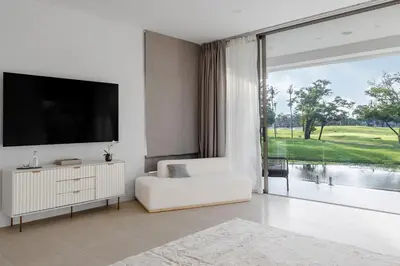 a white living room with a television and a white couch at \u62c9\u53e4\u5a1c\u9ad8\u5c14\u592b\u4ff1\u4e50\u90e8\u522b\u5885 in Ban Nong Chaeng